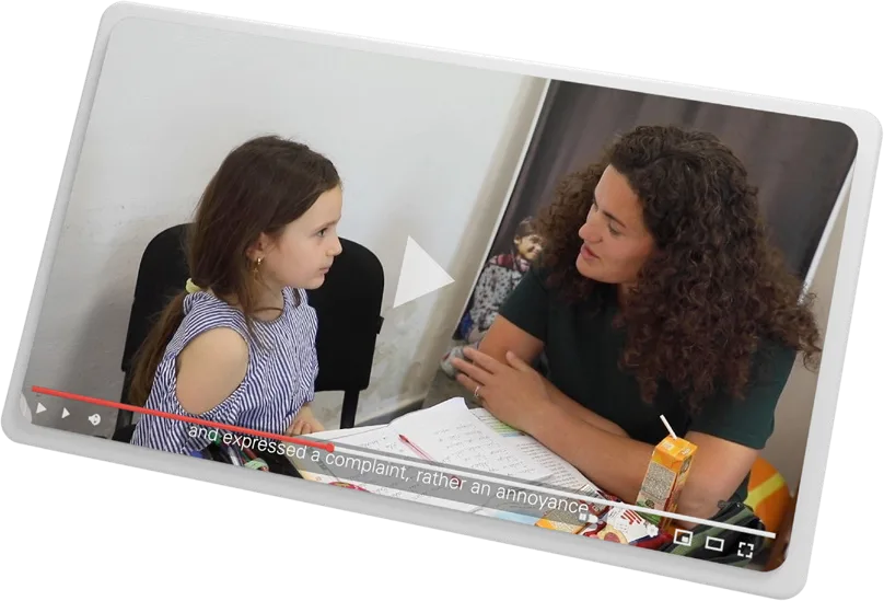 A frame from the documentary: a young girl and a counsellor talking at a desk
